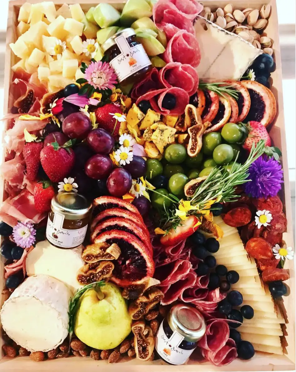 Delicious cheese board with meats, crackers, olives, nuts + paring jams